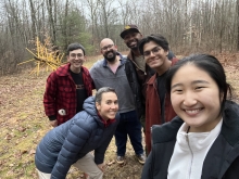 6 students and mentors smile in the forest in winter