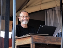 Photo shows Chris Field at a podium with a computer.