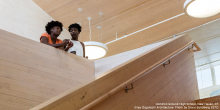 Students standing in wooden building.