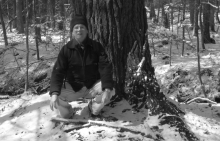David Kittredge kneeling in front of a tree.