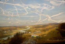 Condensation trails in the blue sky over an open landscape.