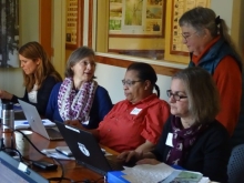 Mentors Ann Lewis and Betsy Colburn work on computers with 3 Schoolyard Ecology teachers in a conference room.