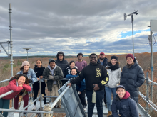 Image shows Harvard University students atop a Harvard Forest research tower. By Clarisse Hart. 