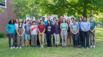 Interns participating in the 2024 Summer Research Program in Ecology stand outside on Harvard Forest's campus.