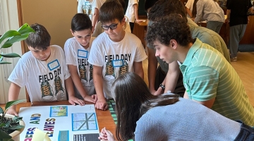 Image shows students reviewing a poster at Harvard Forest's 2024 Data Jam. Photo by student Ava Rubin.