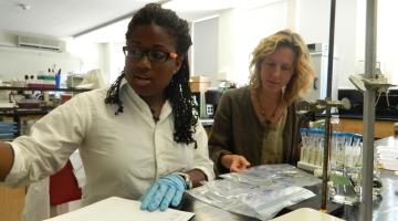 Student intern Tiffaney Carey and mentor Kristina Stinson analyze samples in the lab