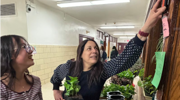 Image shows Elisa Margarita, right, working with a student at a plant wall in her school. Image by Elisa Margarita.