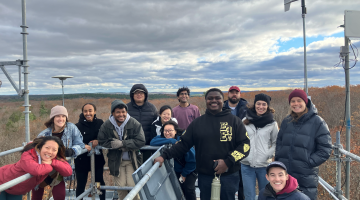 Image shows Harvard University students atop a Harvard Forest research tower. By Clarisse Hart. 