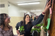 Image shows Elisa Margarita, right, working with a student at a plant wall in her school. Image by Elisa Margarita.