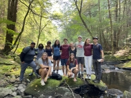 Freshman Seminar students pose at a stream during a field visit