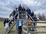 Image shows the 2023 First-Year students standing on a stile at the Harvard Farm.