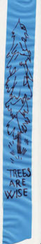 A piece of plastic ribbon with a sketch of a tree and the words "Trees are wise" written in black marker