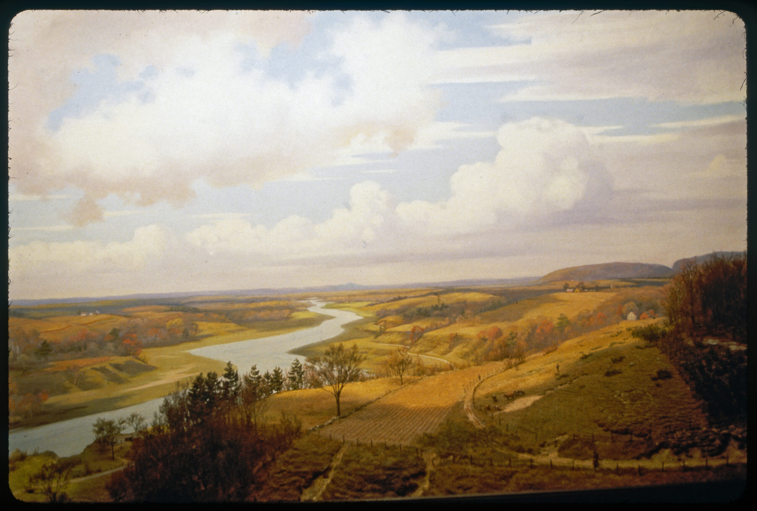 Diorama scene of a river with farmland on either side that shows signs of soil erosion